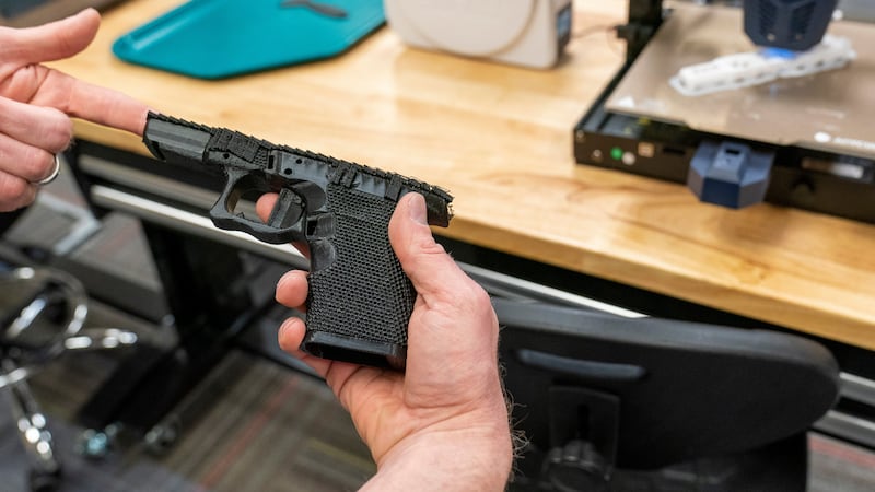 FILE - A handgun frame that has been printed on a 3D printer is held for a photograph at the...
