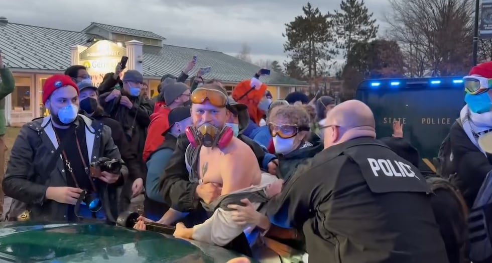 Police attempt to detain a protester in South Burlington on Wednesday.